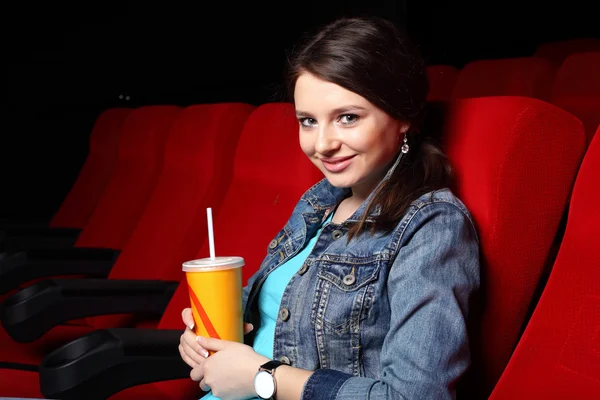 Молодая девушка в кино смотрит кино — стоковое фото