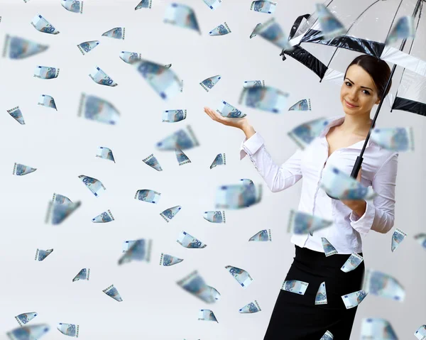 Mujer de negocios bajo lluvia de dinero con paraguas — Foto de Stock