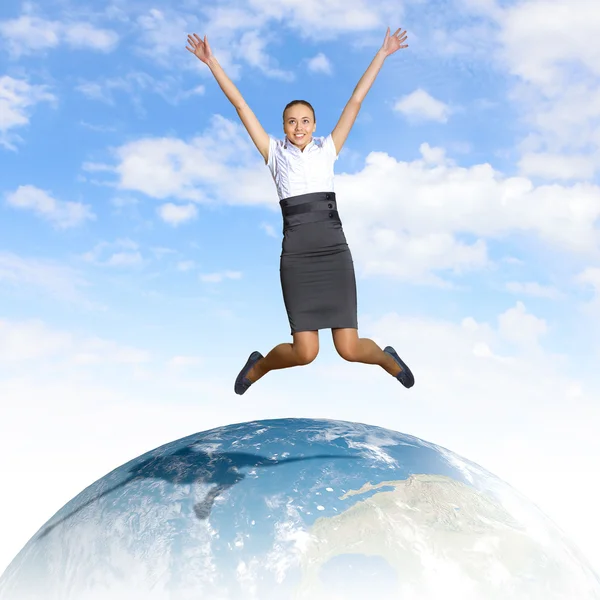 Mujer joven saltando y nuestro planeta tierra — Foto de Stock