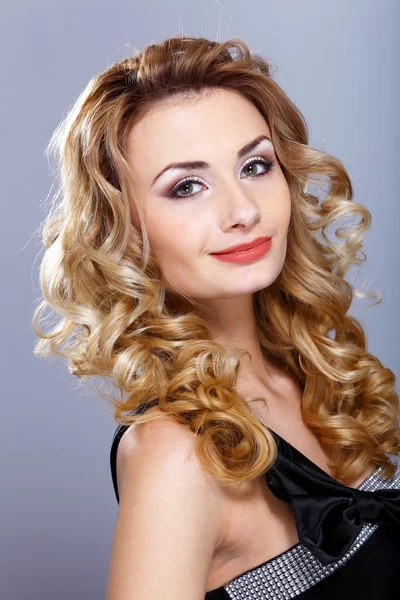 Young woman in black dress with curly hair — Stock Photo, Image