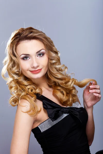 Young woman in black dress with curly hair — Stock Photo, Image