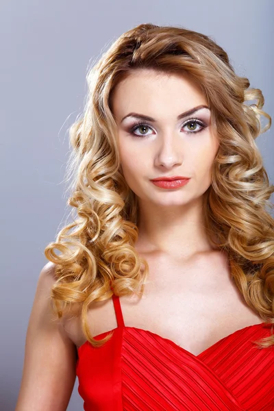 Young woman in red dress with curly hair — Stock Photo, Image