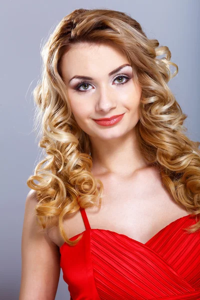 Молодая женщина в красном платье с вьющимися волосами — стоковое фото