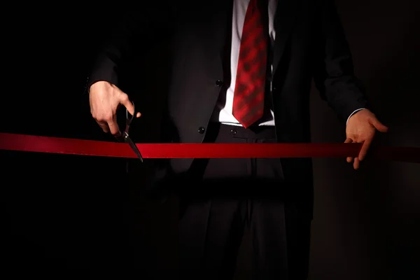 stock image Businessman with scissors cuting a red ribbon