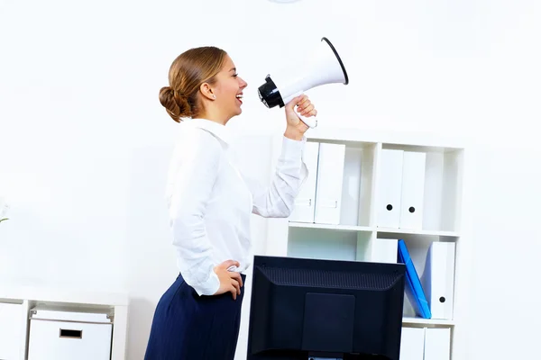 Young woman with megaphone in office — Stock Photo, Image