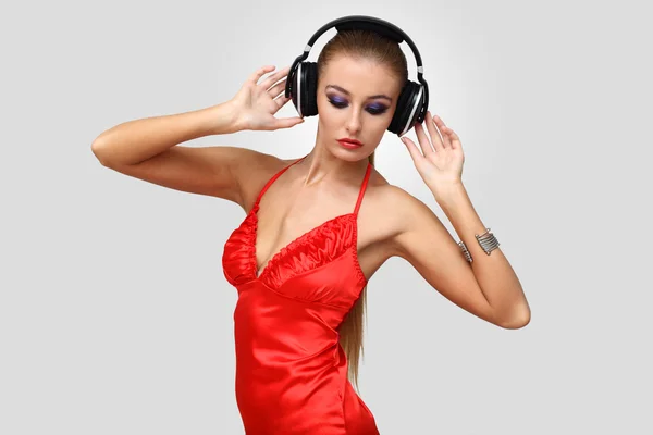 Jeune femme en robe de soirée avec écouteurs — Photo