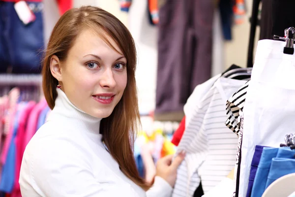 Mladá žena uvnitř obchodu, nákup oblečení — Stock fotografie