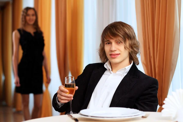 Junger schöner Mann sitzt im Restaurant — Stockfoto