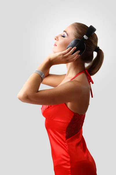 Młoda kobieta w sukni z słuchawki — Zdjęcie stockowe