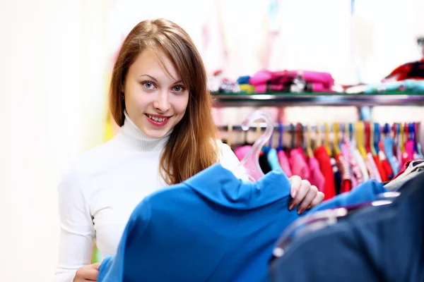 Fiatal nő vásárol ruhát felsőrészre — Stock Fotó