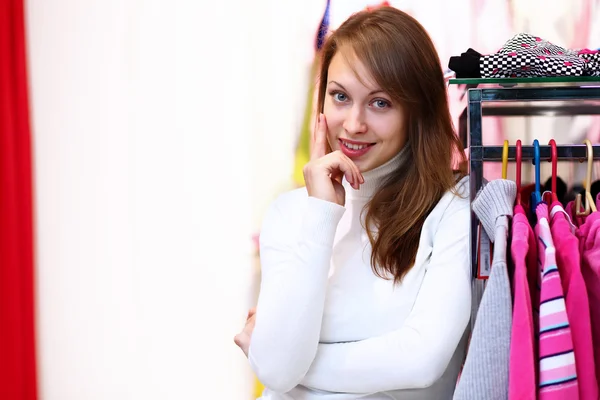 Молодая женщина в магазине покупает одежду — стоковое фото