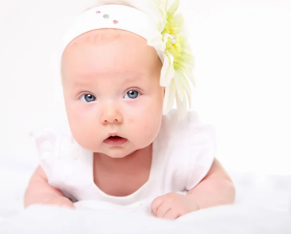 Portrait of a baby girl with a flower on her head — Stock Photo, Image