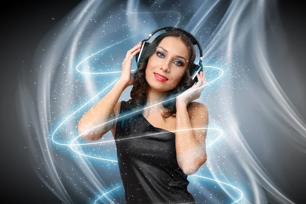 Mujer joven en vestido de noche con auriculares — Foto de Stock