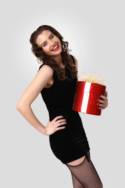 Mulher de vestido preto com uma caixa de presente — Fotografia de Stock