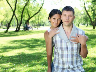 Couple spending time together in the summer park clipart