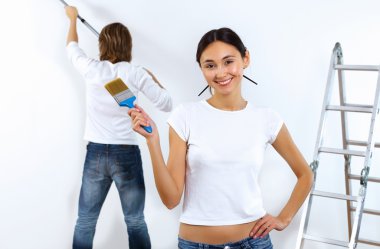 Young couple with paint brushes together clipart