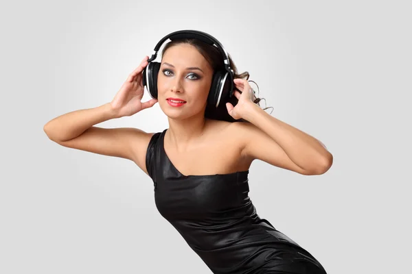 Jovem mulher em vestido de noite com fones de ouvido — Fotografia de Stock