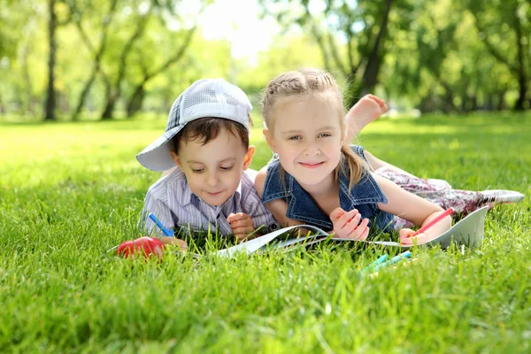Kinderen in het park lezen van een boek — Stockfoto