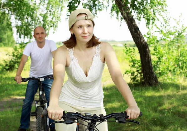 Młoda para na rowerach w parku — Zdjęcie stockowe