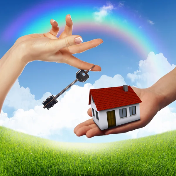 Hus och mänsklig hand mot blå himmel — Stockfoto