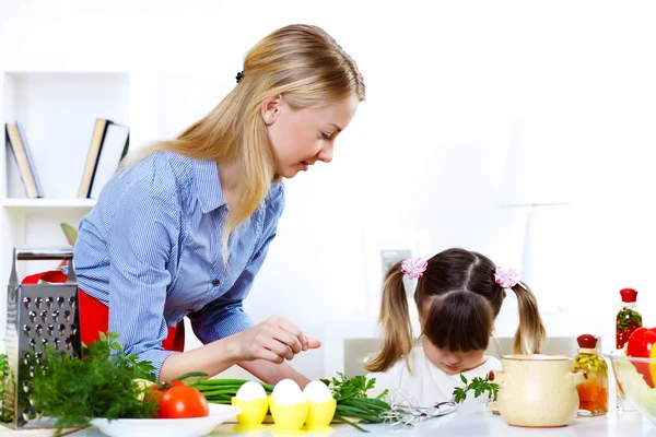 Junge Mutter kocht zuhause mit ihrem Töchterchen — Stockfoto