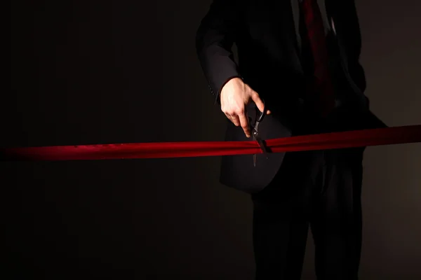 stock image Businessman with scissors cuting a red ribbon