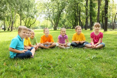 Grup birlikte parkta oturan çocuk