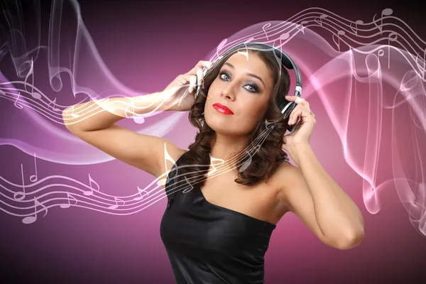 Young woman in evening dress with headphones Stock Picture