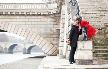 Beautiful romantic couple kissing on a Parisian embankment at sp clipart