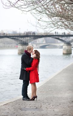 Romantic couple in love kissing near Pont des Arts in Paris clipart