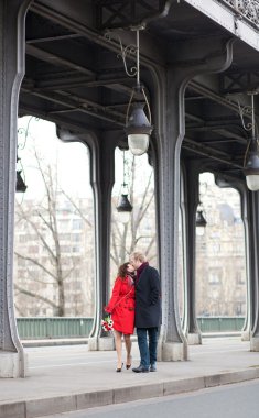 Romantic couple kissing on the Bir-Hakeim bridge clipart