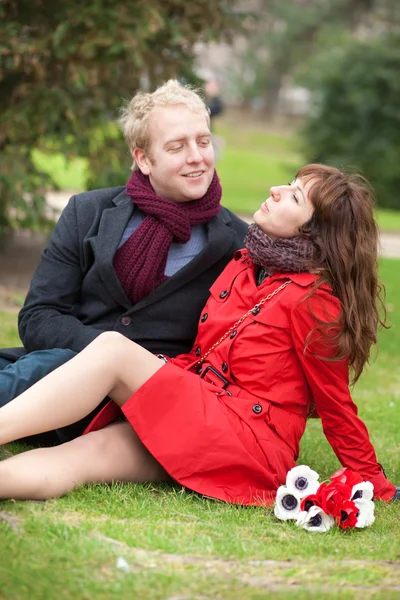 Šťastný pár v lásce s datum a sedět na trávě — Stock fotografie