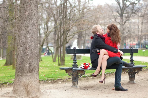 Счастливая романтическая пара, обнимающаяся на скамейке — стоковое фото