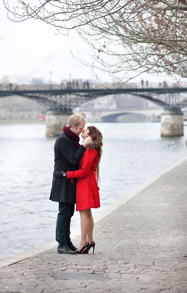 Romantic couple in love kissing near Pont des Arts in Paris