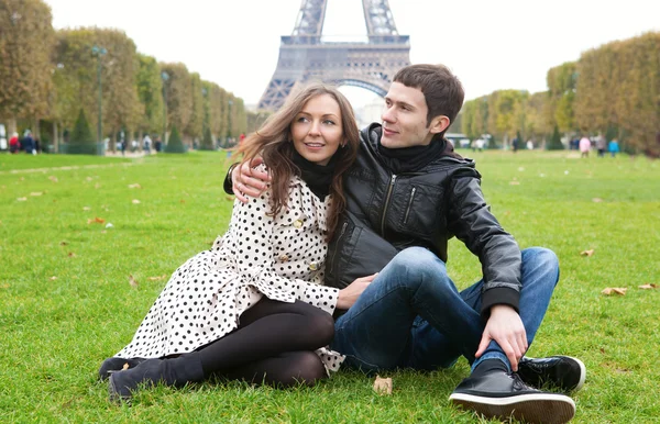 Pareja romántica joven sentada cerca de la torre Eiffel — Foto de Stock