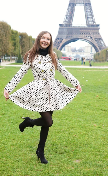 Mooie jonge vrouw in polka dot loopgraaf in de buurt van de Eiffeltoren — Stockfoto