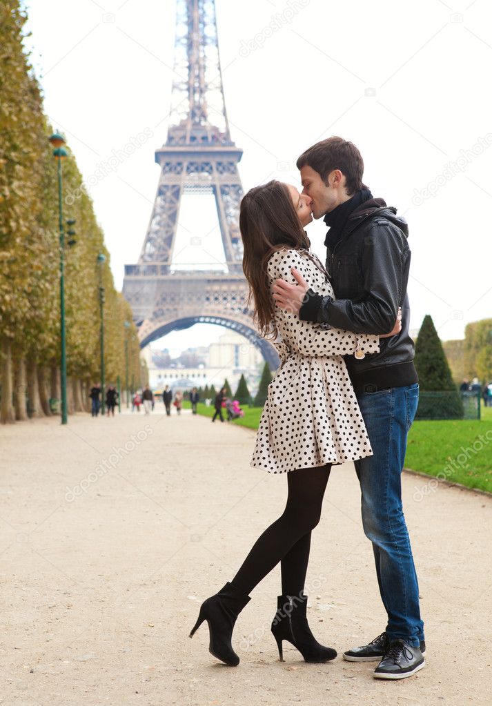 Young romantic couple kissing near the Eiffel Tower in Paris
