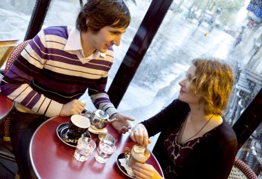 Happy couple in a Parisian cafe at rain clipart