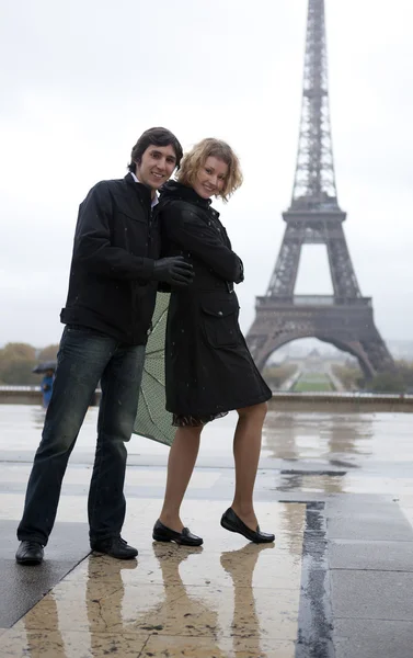 Happy couple near the Eiffel tower at rain — Stock Photo, Image