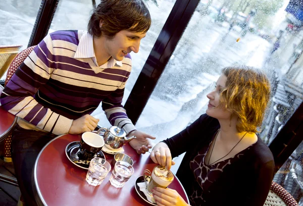 Casal feliz em um café parisiense à chuva — Fotografia de Stock