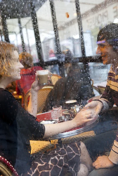Pareja feliz en un café parisino bajo la lluvia — Foto de Stock