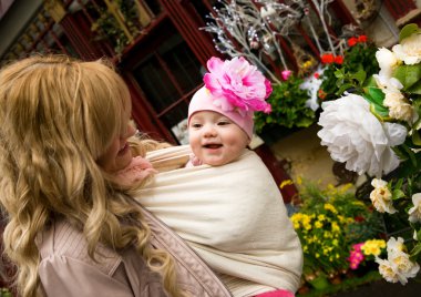 Young mother with beautiful baby daughter in a garden. Mother is clipart