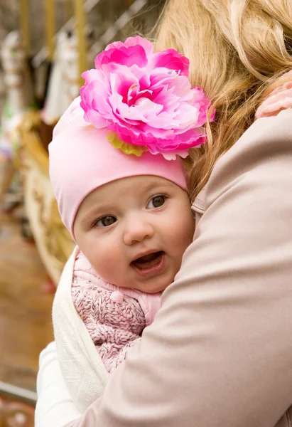 Cheerful beautiful baby girl in her mother's arms — Stock Photo, Image