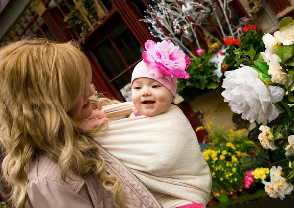 Young mother with beautiful baby daughter in a garden. Mother is — Stock Photo, Image