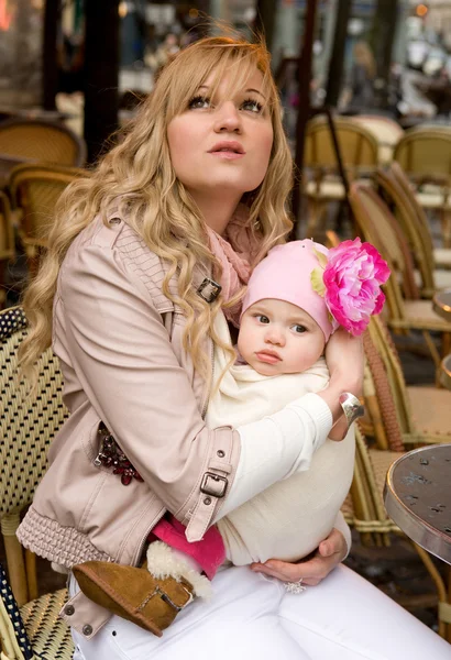 Bela jovem mãe com sua filha bebê em um stre parisiense — Fotografia de Stock