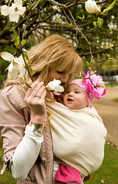 स्प्र में एक गार्डन में अपनी बेबी बेटी के साथ सुंदर युवा माँ — स्टॉक फ़ोटो, इमेज
