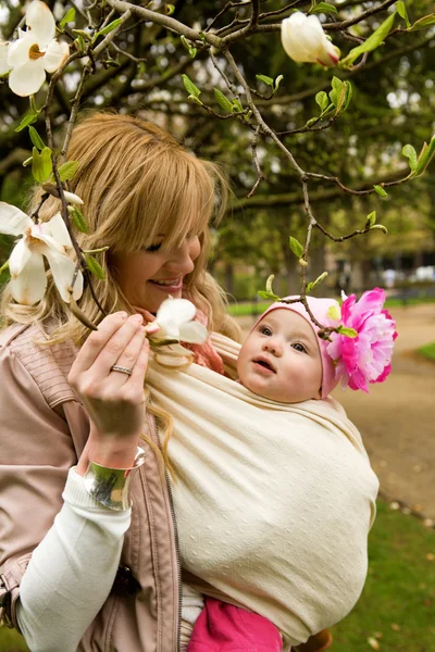 Piękna młoda matka z córką dziecka w ogrodzie w spr — Zdjęcie stockowe