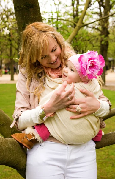 Schöne junge Mutter und kleine Tochter haben Spaß im Freien bei — Stockfoto