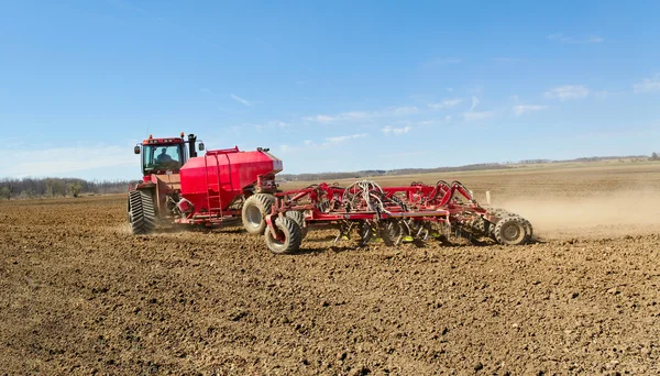 Röd traktor på ett fält. — Stockfoto