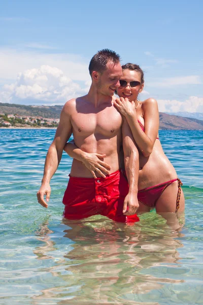 Hübsches Paar, das sich im Wasser umarmt — Stockfoto